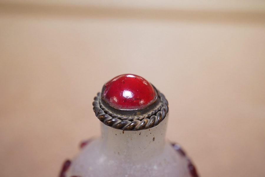 A Chinese cameo carved red overlaid on white snowflake ground snuff bottle and stopper, 19th century, 8cm high. Condition - small splinter chip to base, otherwise good